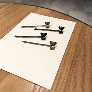 Lot de quatre barrettes ours minimalistes en noir et marron sur carte d'exposition