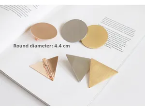 Macro detail of geometric brushed metal hair clips in gold, silver and rose gold