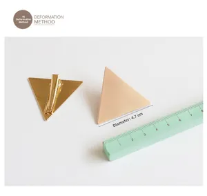 Detail of 4.7cm golden triangle hair clip with matte brushed metal finish and clip base