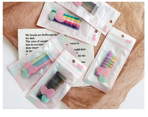 Detailed view of colorful macaron bobby pins in heart-decorated clear packaging bags