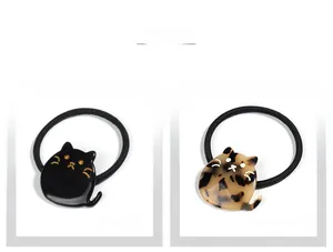Détail d'élastiques à cheveux chat en acétate, coloris noir élégant et motif léopard