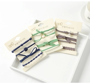 Detail view of elastic hair ties set with pearls and ribbons on display cards