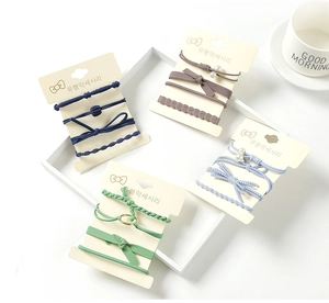 Detail of four-piece elastic hair tie set with pearls and bows in Morandi colors