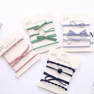 Set of 4 elastic hair ties with pearls and bows on cardboard display cards