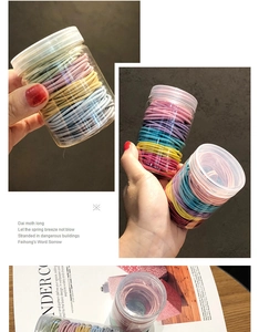Detailed view of colorful elastic hair ties set stored in a clear cylindrical plastic jar