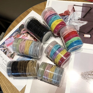 Colorful high-elastic hair ties set in clear jars displayed on a wooden desk setup