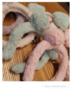 Detailansicht bunter Plüsch-Bärenohr-Stirnbänder in Rosa, Grün und Violett