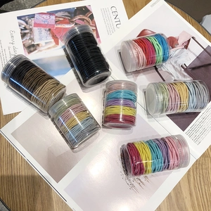 Colorful elastic hair ties set in clear jars on a stylish magazine and wooden desk
