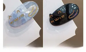 Détail de barrettes chat mignonnes en marbre bleu et noir avec contours dorés