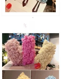 Detail showing the fluffy texture of pink and beige curly plush wool hair clips in a set