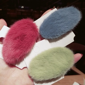 Detailed view of red blue and green faux rabbit fur plush BB hair clips for winter