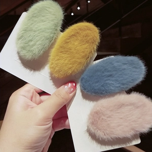 Close-up of colorful plush faux rabbit fur BB hair clips on a display card
