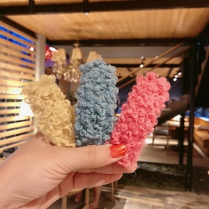 Three colorful plush lamb wool hair clips in beige, blue, and pink colors for women