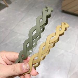 Detail of matte wavy headbands in dark green and yellow with non-slip inner teeth