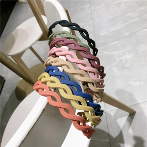 Detailed close-up of matte braided headbands in eight vibrant candy colors on a chair