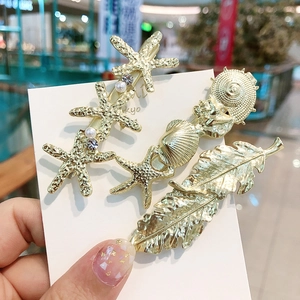 Détails de 3 barrettes dorées avec motifs étoile de mer, coquillage et perles