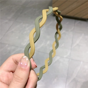 Detail showing two-tone wavy headband with olive green and mustard yellow resin texture
