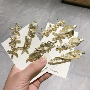 Barrettes à cheveux dorées avec étoiles de mer et perles pour une coiffure élégante