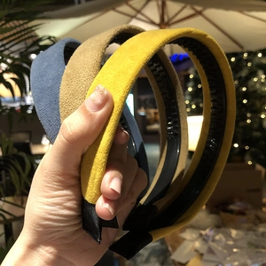 Detail of three velvet headbands in yellow and brown showing non-slip teeth structure
