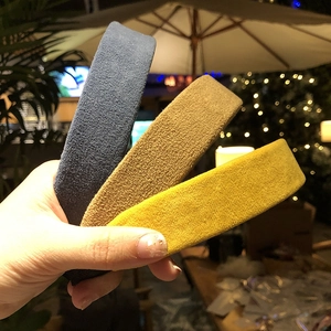 Detailed close-up of wide velvet headbands in yellow, brown, and grey soft textures