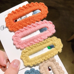 Detail of colorful knitted BB hair clips showing intricate crochet texture and wavy edges