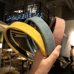 Handheld solid color suede headbands in yellow, blue, and pink with matte texture