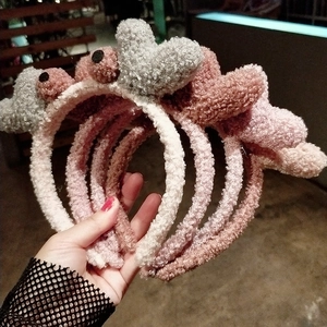 Détail de plusieurs serre-têtes en peluche douce avec décors 3D de cœurs et étoiles