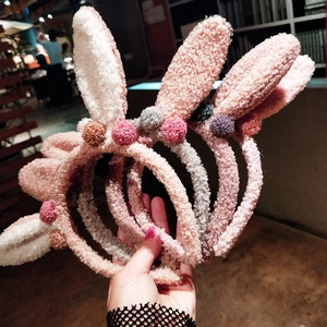 Détail du serre-tête oreilles de lapin en peluche avec texture douce et pompons colorés