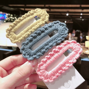 Detailed macro view of three colorful handmade crochet knit hair clips on white card