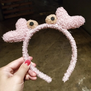 Gros plan d'un serre-tête rose en laine d'agneau avec yeux et détails de dessin animé