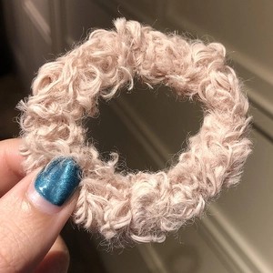 Close-up of a soft light pink fuzzy faux fur scrunchie with plush texture for hair