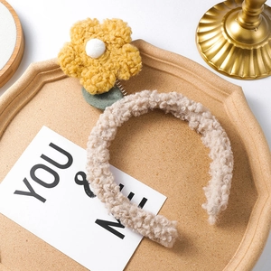 Detail of plush beige teddy hairband with a yellow flower on a spring for women