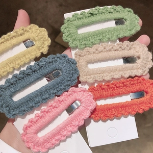 Close-up of six handmade crochet BB hair clips in pastel colors on white display cards