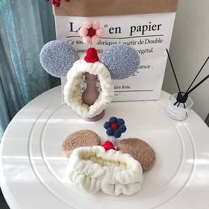Detail van pluche hoofdbanden met berenoren en gehaakte bloemen voor gezichtsverzorging