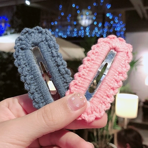 Detailed macro view of handmade pink and blue crochet knit scallop-edged BB hair clips