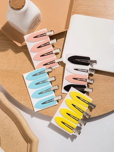 Set of four colorful seamless hair clips displayed on white card packaging for styling