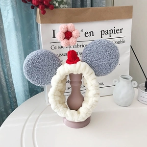 Detail van pluche hoofdband met dierenoren en gebreide muts voor gezichtsreiniging