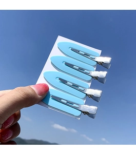 Set of four sky blue seamless hair clips with silver metal grip on display card