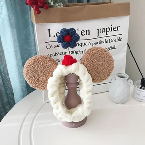 Detail van de zachte crème pluche hoofdband met bruine berenoren en een schattig bloemetje