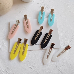 Set of five colorful matte seamless hair clips arranged neatly on a white display card