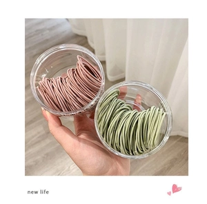 Détail des chouchous colorés à haute élasticité dans des pots de rangement cylindriques