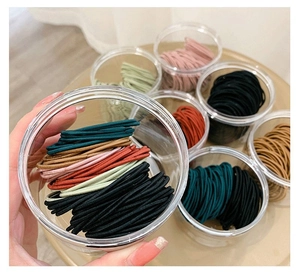 Détail d'élastiques à cheveux colorés haute élasticité rangés dans des bocaux en plastique