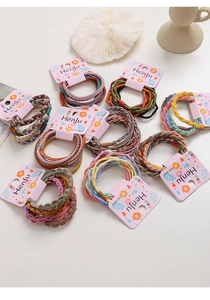 Detailed view of elastic braided hair bands in various colors on floral cardboards