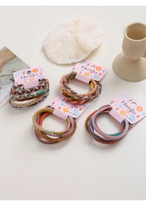 Detailed view of high-elastic braided hair ties on pink display cards with soft lighting