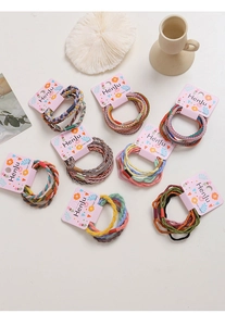 Detail shot of colorful braided elastic hair bands on decorative pink display card