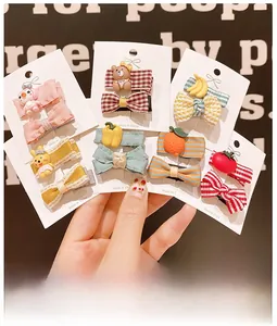 Close-up of cute cartoon hair clips featuring fabric bows and resin animal charms for girls