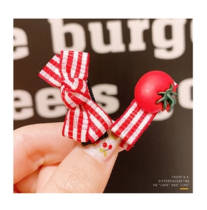 Close-up of cute red gingham bow hair clip and 3D tomato hairpin for children girls