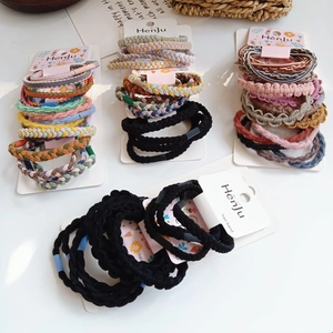 Detailed view of colorful braided hair bands sets on white cardboard display cards