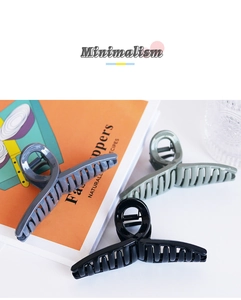 Detailed view of minimalist high-gloss plastic hair claws in blue, green and black