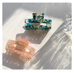 Detail of two-piece acetate hair claws with colorful tortoiseshell and floral patterns